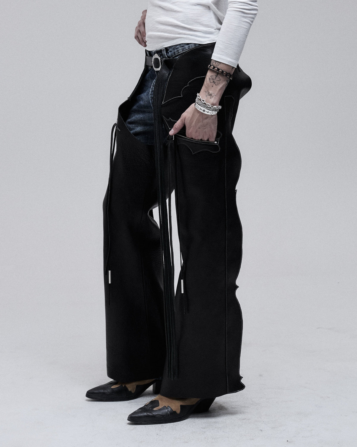 Riding Chaps in black leather, three-quarter view on model