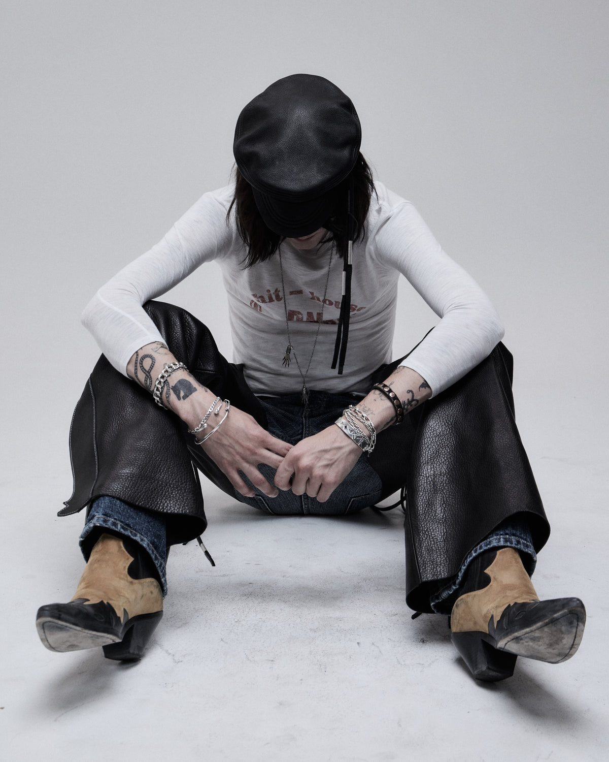Riding Chaps in black leather, worn by a seated model