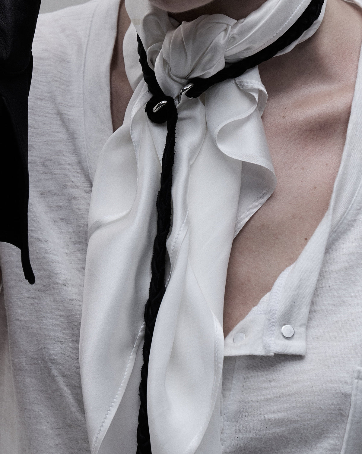 Tassel necklace worn as a necktie over a white shirt