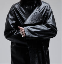 Jeffrey Coat in black, close-up of the asymmetric front